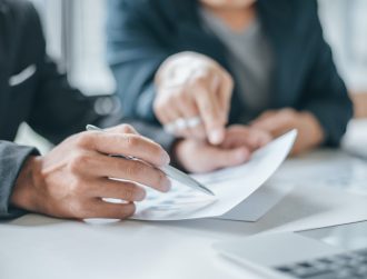 Businessman pointing hand at the data graph to analyze and planning financial and investment strateg